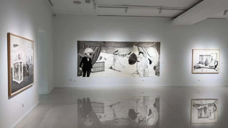 Interior de la sala con exposición de obras artísticas en blanco y negro