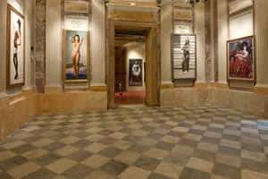 Salón principal con suelo a cuadros y obras expuestas en las paredes