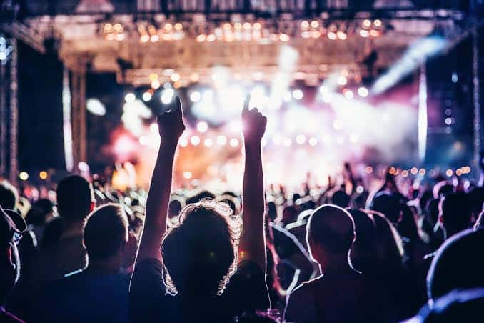 Vista desde la multitud en un concierto con luces de escenario
