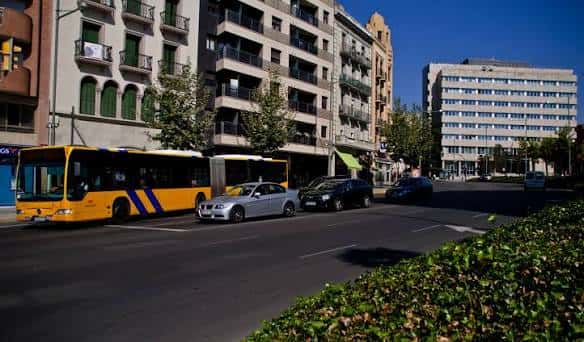 Vista panorámica de la Rambla d'Aragó con autobuses y edificios residenciales bajo un cielo despejado