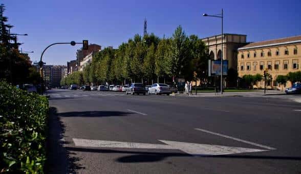 Avenida arbolada de la Rambla d'Aragó con tráfico fluido y edificio institucional al fondo
