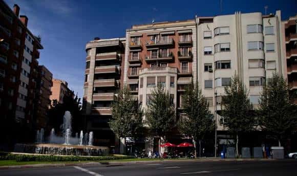 Plaza con fuente en la Rambla d'Aragó, rodeada de bloques de viviendas y árboles