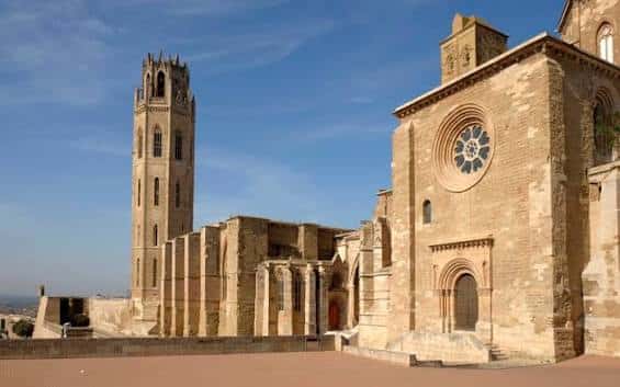 Detalle arquitectónico de la Catedral de la Seu Vella con su torre campanario bajo cielo azul