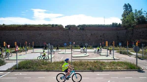 Vista general del parque infantil de tráfico con niños en bicicletas y señales de tránsito