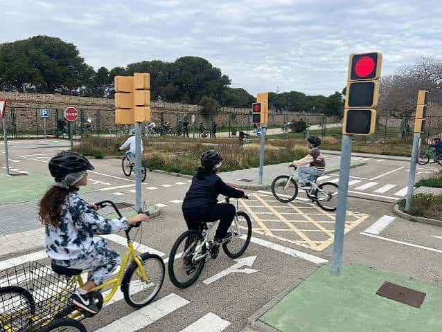 Niños circulando por el circuito de bicicletas bajo la supervisión de semáforos