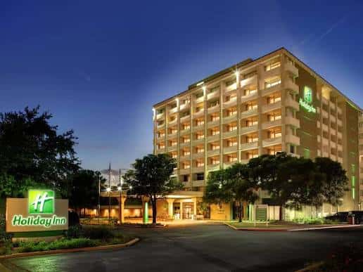 Vista exterior nocturna del Holiday Inn Austin Midtown con fachada iluminada