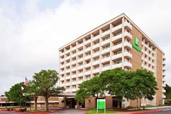 Fachada diurna del hotel mostrando su arquitectura moderna y entorno arbolado