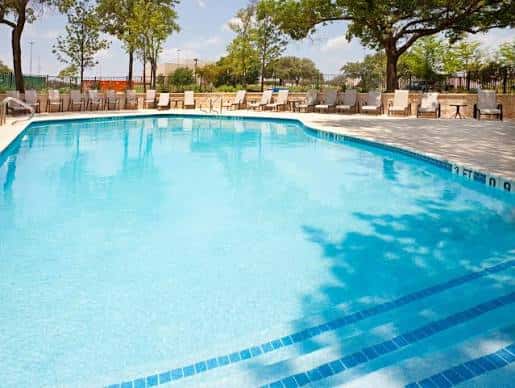 Piscina al aire libre del hotel con tumbonas y zona de descanso
