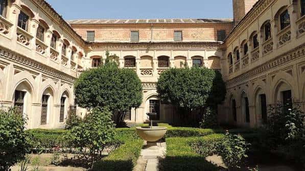 Vista del claustro principal con arcos góticos y jardín central