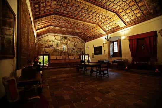 Sala interior con techos de artesonado mudéjar y mobiliario histórico