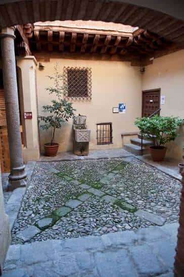 Patio interior con suelo de adoquines y columnas de piedra