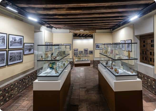 Sala de exposiciones con vitrinas y techo de vigas de madera