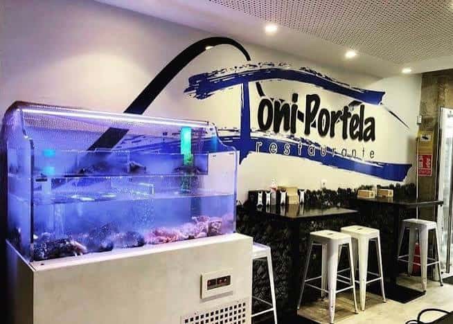 Interior del restaurante Toni Portela con acuario de mariscos y barra