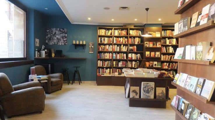 Espacio interior acogedor de la librería con estanterías y zona de lectura
