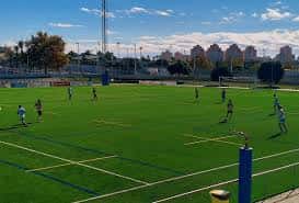 Vista del campo de fútbol Nelson Mandela con jugadores en el césped