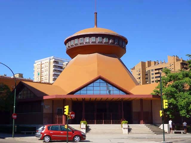 Vista exterior de la Iglesia de Santa Mónica con su distintiva cúpula naranja y arquitectura moderna