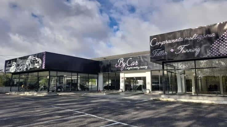 Fachada exterior del concesionario Bycar en Lugo con letreros de compraventa y tuning