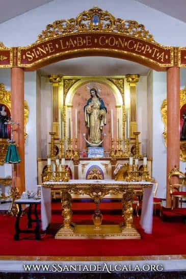 Altar principal con imagen de la Virgen enmarcada por decoración dorada