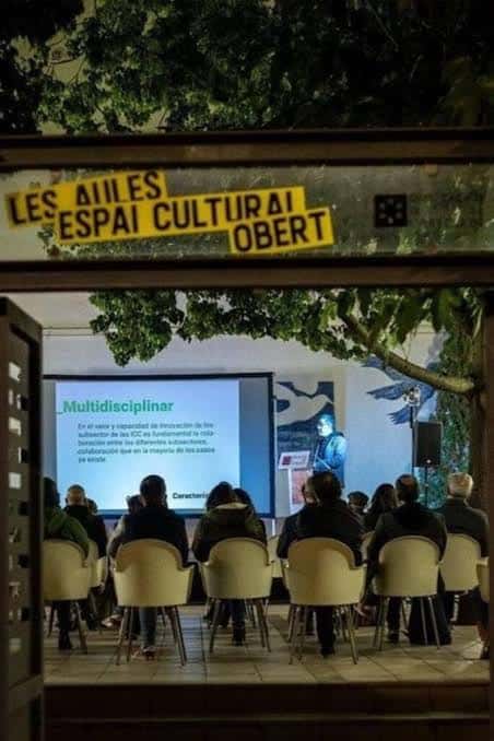 Presentación o conferencia en el espacio abierto de Les Aules vista desde la entrada