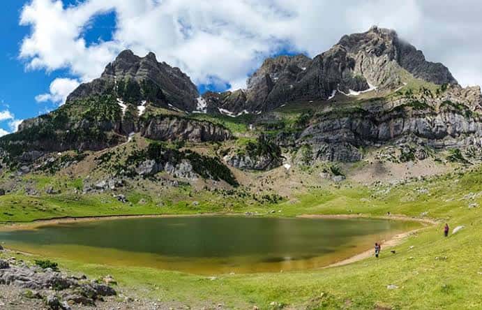 Vista panorámica del Ibón de Piedrafita con montañas rocosas y cielo azul