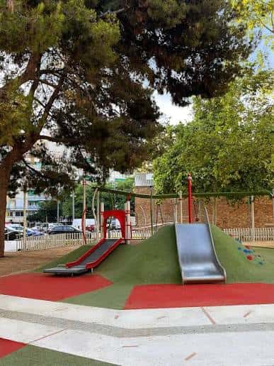 Área de juegos infantiles con toboganes y suelo de caucho en los Jardines Celestina Vigneaux