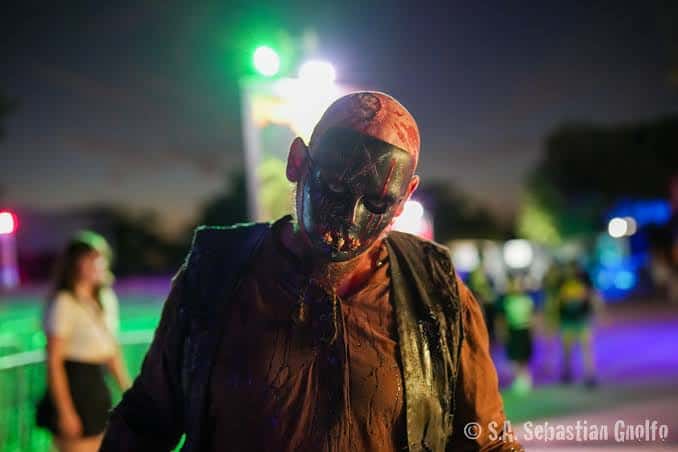 Actor con maquillaje sangriento y máscara durante el evento nocturno