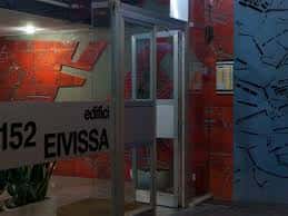 Entrada moderna del edificio con señalización 'Edifici Eivissa' y paredes decoradas