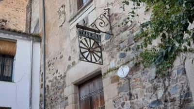 Detalle del letrero colgante de la Taberna Sir Lancelot en piedra antigua