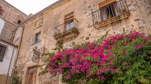 Fachada histórica de la Taberna Sir Lancelot con flores y balcones tradicionales