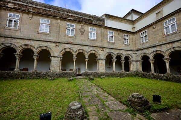 Vista general del claustro del Carmen en Lugo con patio ajardinado y galería de arcos