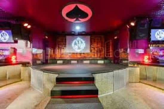 Vista del escenario principal de la discoteca con iluminación roja y el logo de una pica en el techo