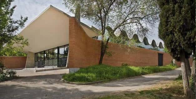Vista exterior del Pabellón de Convenciones con fachada de ladrillo y techo inclinado