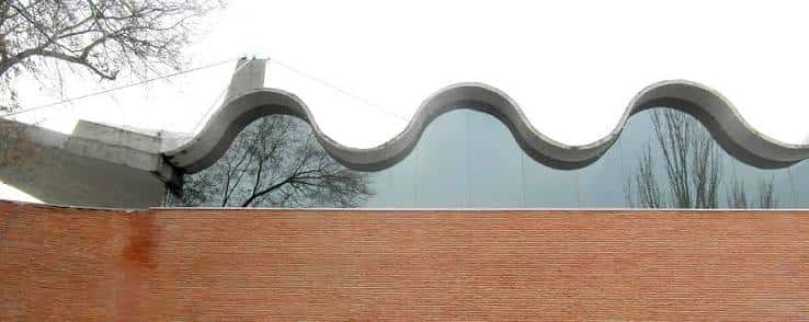 Detalle arquitectónico del techo ondulado y muro de ladrillo