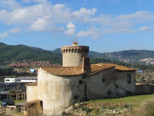 Vista panorámica de la Torre de Can Palauet con el entorno montañoso al fondo