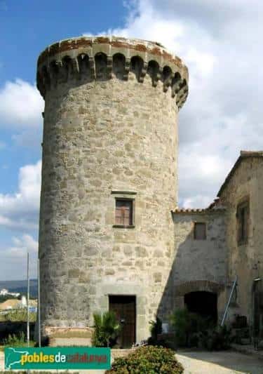Primer plano de la torre circular de piedra con detalles arquitectónicos medievales
