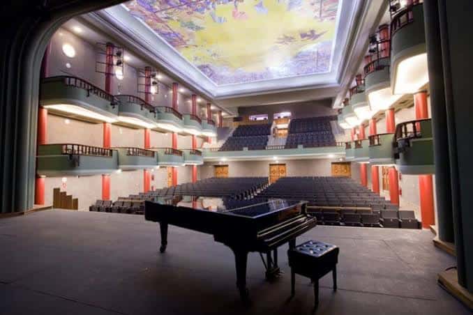 Escenario con piano visto desde el fondo del auditorio