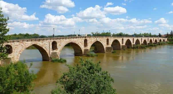 Vista panorámica del Puente de Piedra sobre el río Duero con cielo azul y nubes