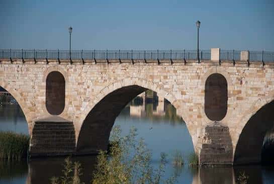 Detalle de los arcos medievales del puente en primer plano bajo luz diurna