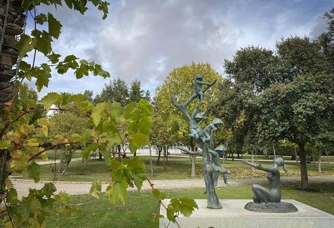 Escultura artística en el jardín rodeada de árboles