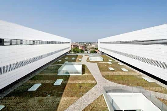 Perspectiva aérea del patio central del hospital con jardines y cubiertas de cristal