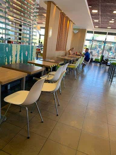 Interior del restaurante McDonald's en Sanlúcar de Barrameda con mesas y sillas modernas