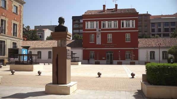 Plaza frontal del edificio cultural con busto escultórico y arquitectura tradicional