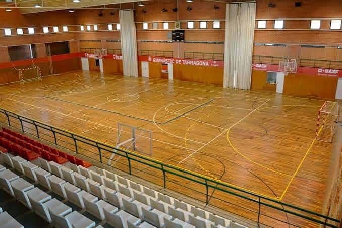 Vista general del interior del polideportivo con gradas y pista de baloncesto