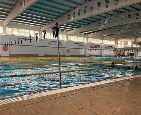 Interior de la piscina cubierta del club con estructura arquitectónica visible