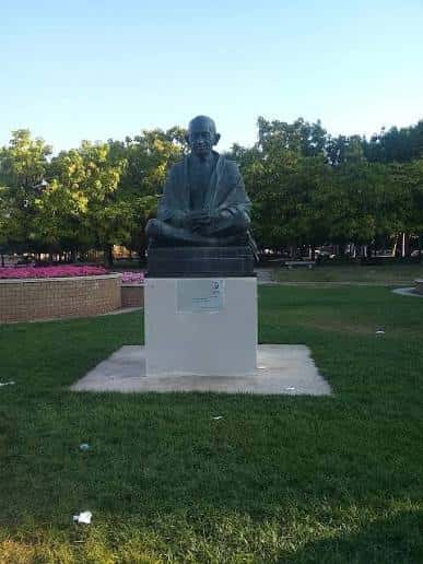 Estatua de Mahatma Gandhi sentada sobre pedestal blanco
