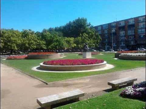 Vista general del parque con jardines circulares y flores rojas