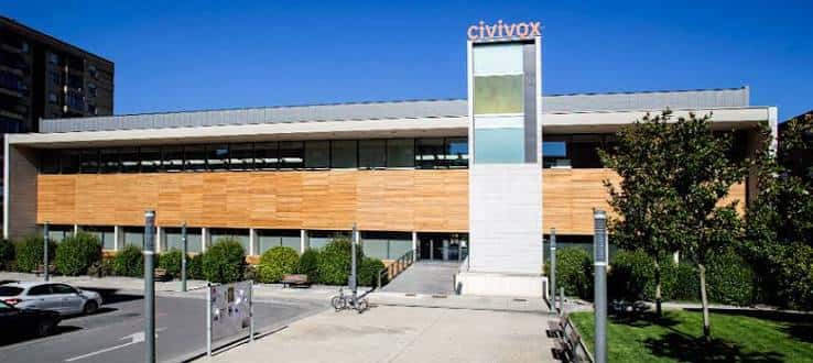 Fachada exterior del Civivox Iturrama con su distintiva torre y revestimiento de madera