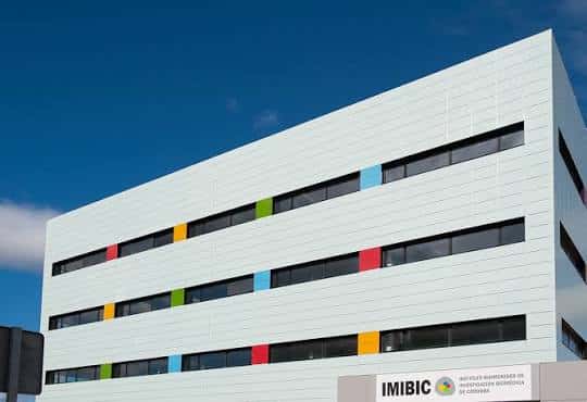 Vista exterior del edificio IMIBIC con fachada blanca y detalles de colores