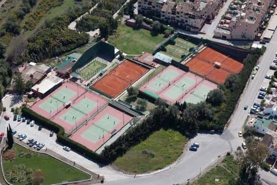 Vista aérea del Club de Tenis y Padel Bel-Air mostrando las pistas de tierra batida y duras rodeadas de vegetación
