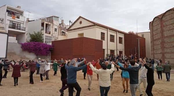Grupo de personas bailando sardanas en la plaza durante una celebración